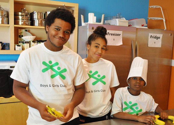 Three youth preparing to cook with bananas.