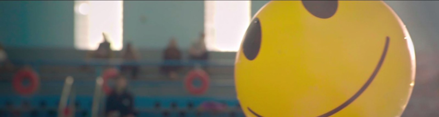 Beach ball with happy face floating in pool