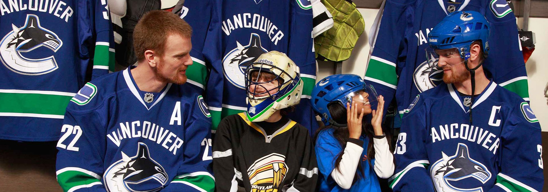 NHL players Daniel and Henrik Sedin with kids