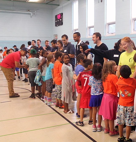A picture of kids and staff lining up in a gym